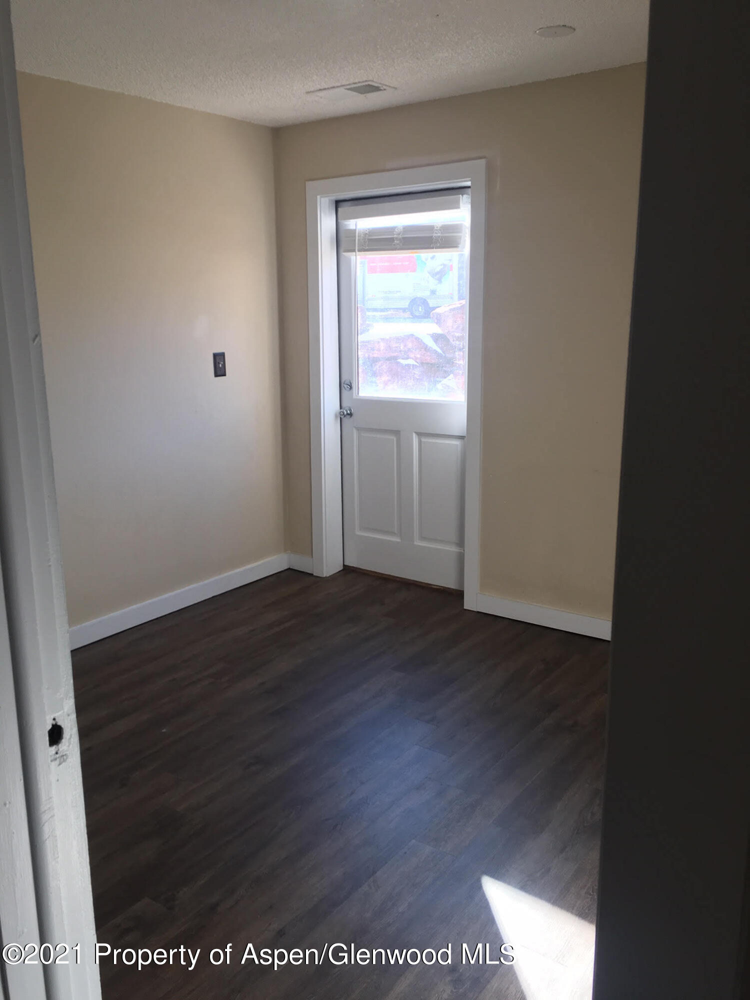 1101 Village Road, Unit LL3B Carbondale, CO 81623 - Photo 16 of 17 a view of an empty room with wooden floor and a window