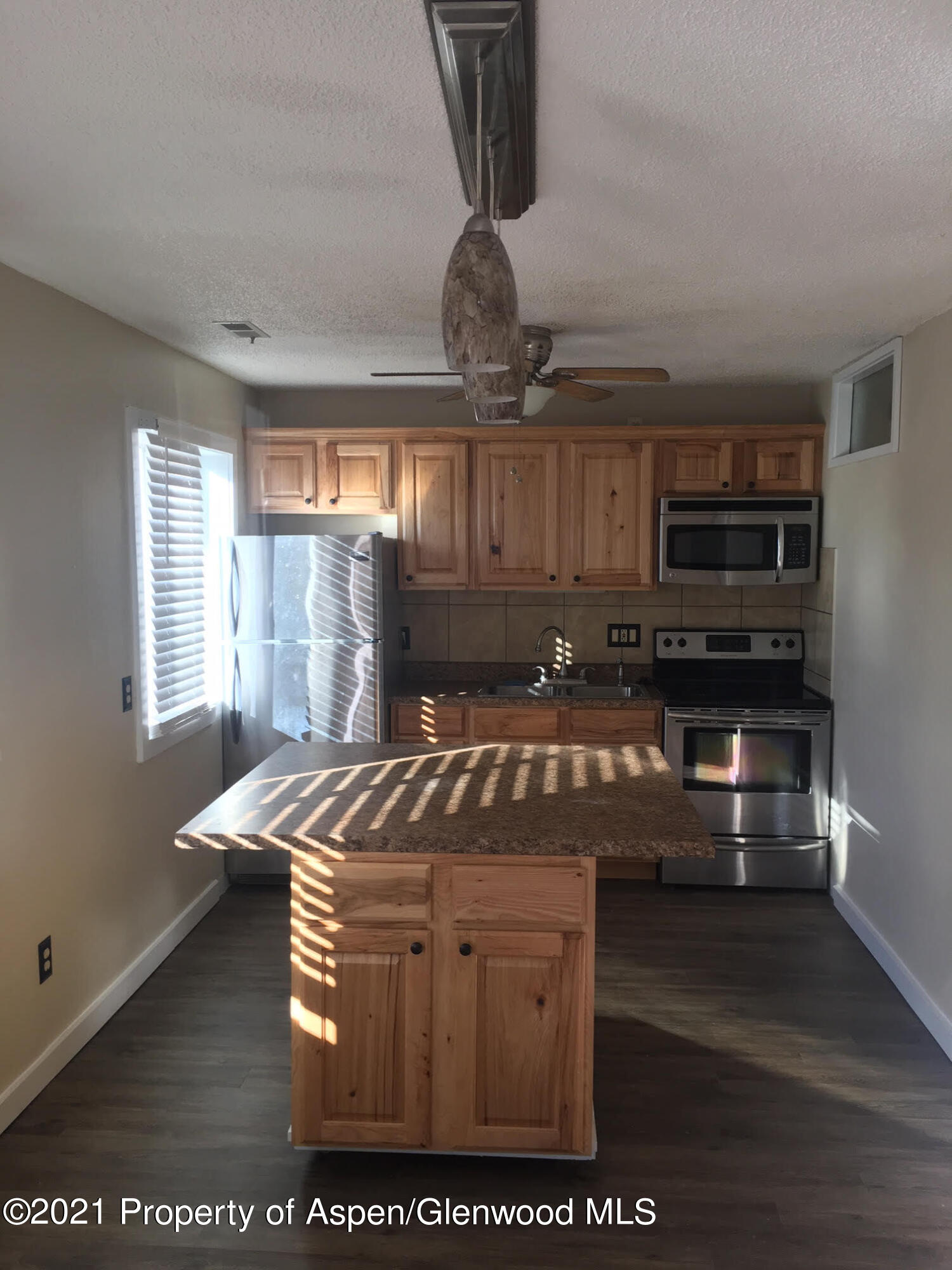1101 Village Road, Unit LL3B Carbondale, CO 81623 - Photo 4 of 17 a kitchen with stainless steel appliances granite countertop a stove a sink and a microwave