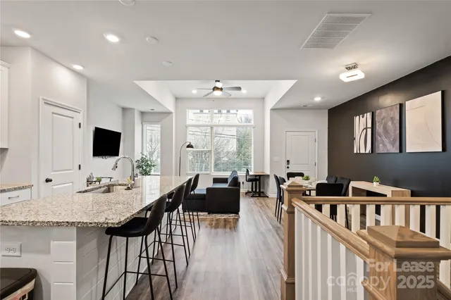 a living room with furniture a flat screen tv and a large window
