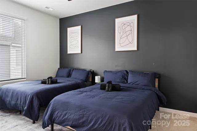 a bed room with two bed and a window