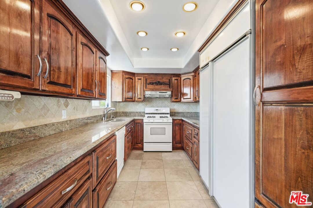 148 Van Nuys Avenue Oxnard, CA 93035 - Photo 18 of 37 a kitchen with stainless steel appliances granite countertop a refrigerator and a stove top oven