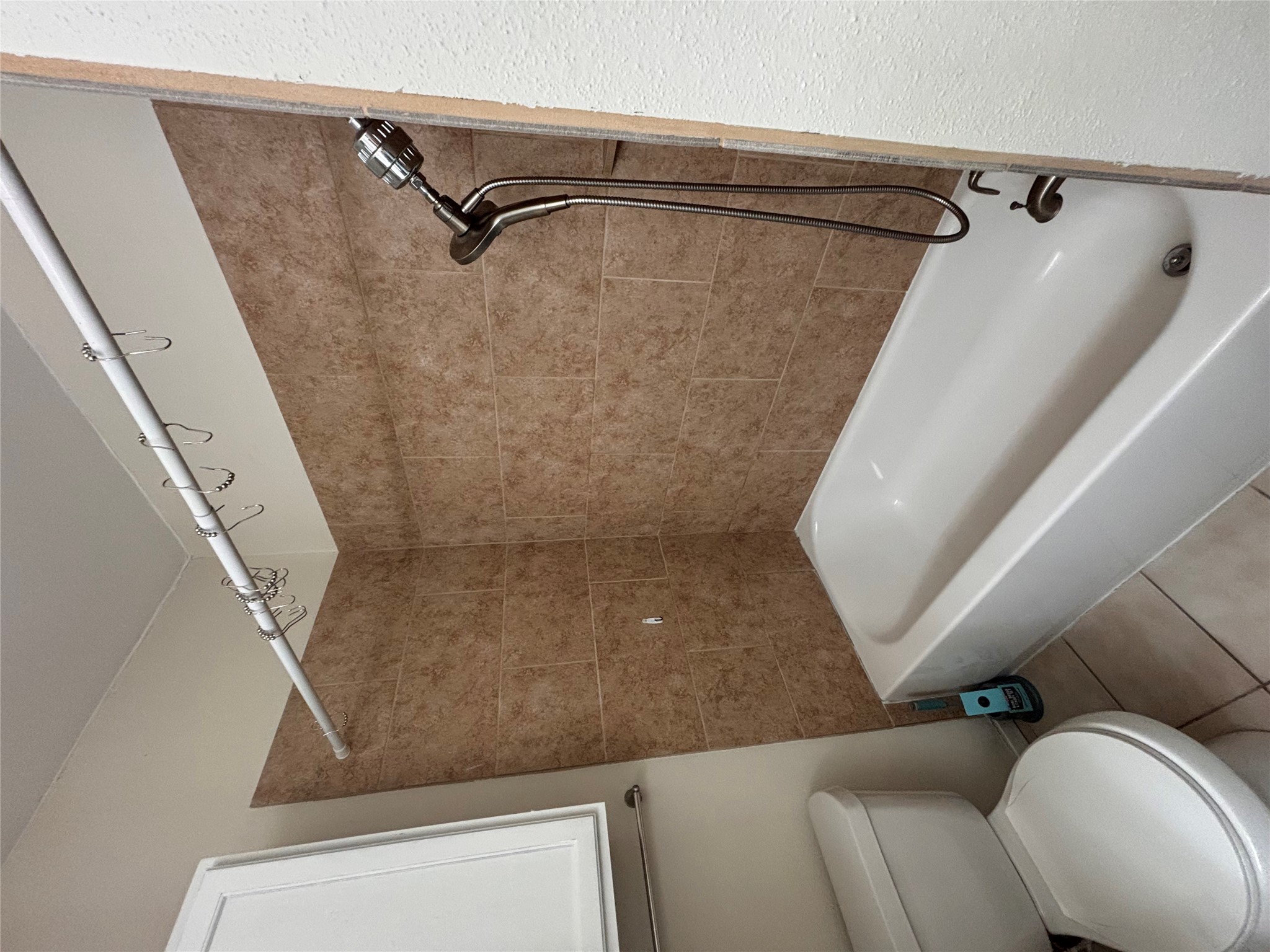 2801 Rio Grande Street, Unit 208 Austin, TX 78705 - Photo 20 of 25 A well-appointed bathroom features a bathtub with a tiled shower surround and clean tile flooring.