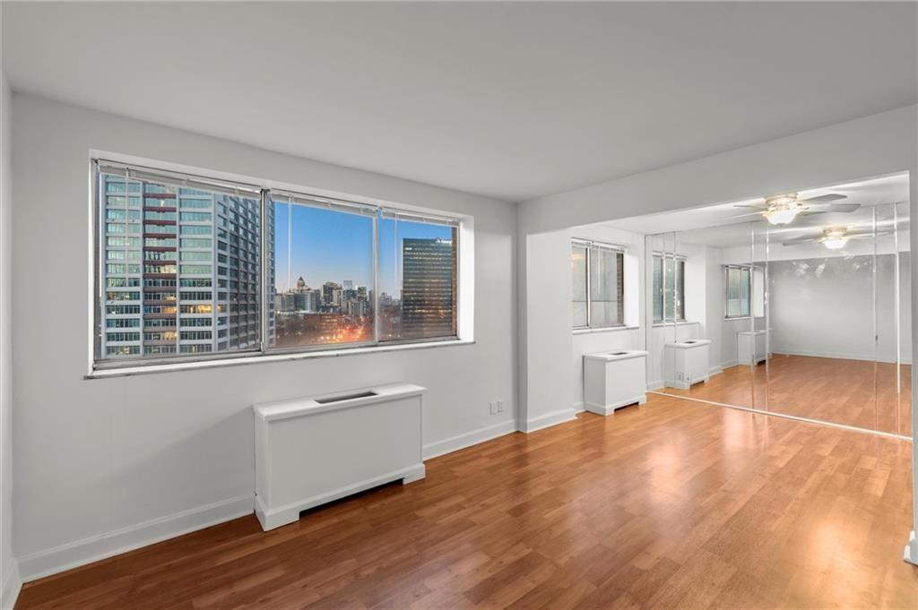 215 Piedmont Avenue Northeast, Unit 1608 Atlanta, GA 30308 - Photo 11 of 25 a room with wooden floor and windows