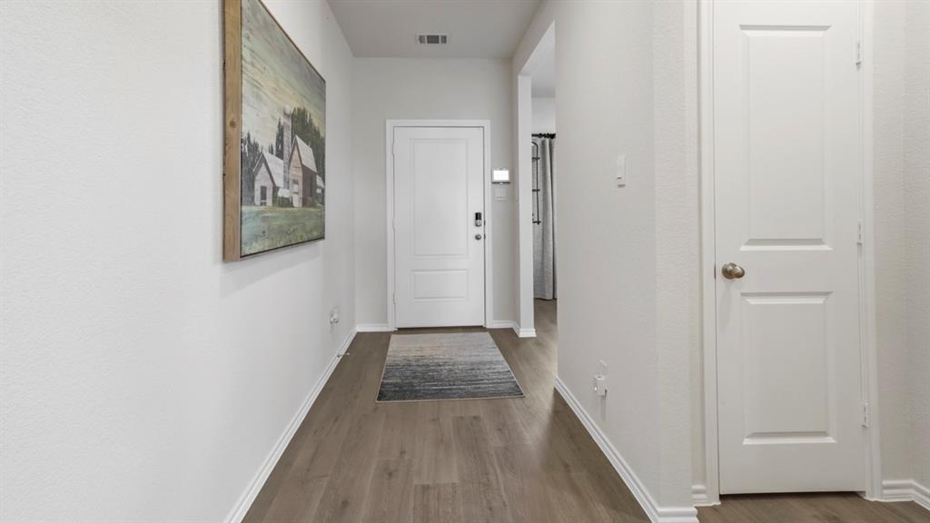 636 Dunham Road Nevada, TX 75173 - Photo 16 of 31 Entryway featuring wood-finish flooring, white baseboards, and a paneled interior door