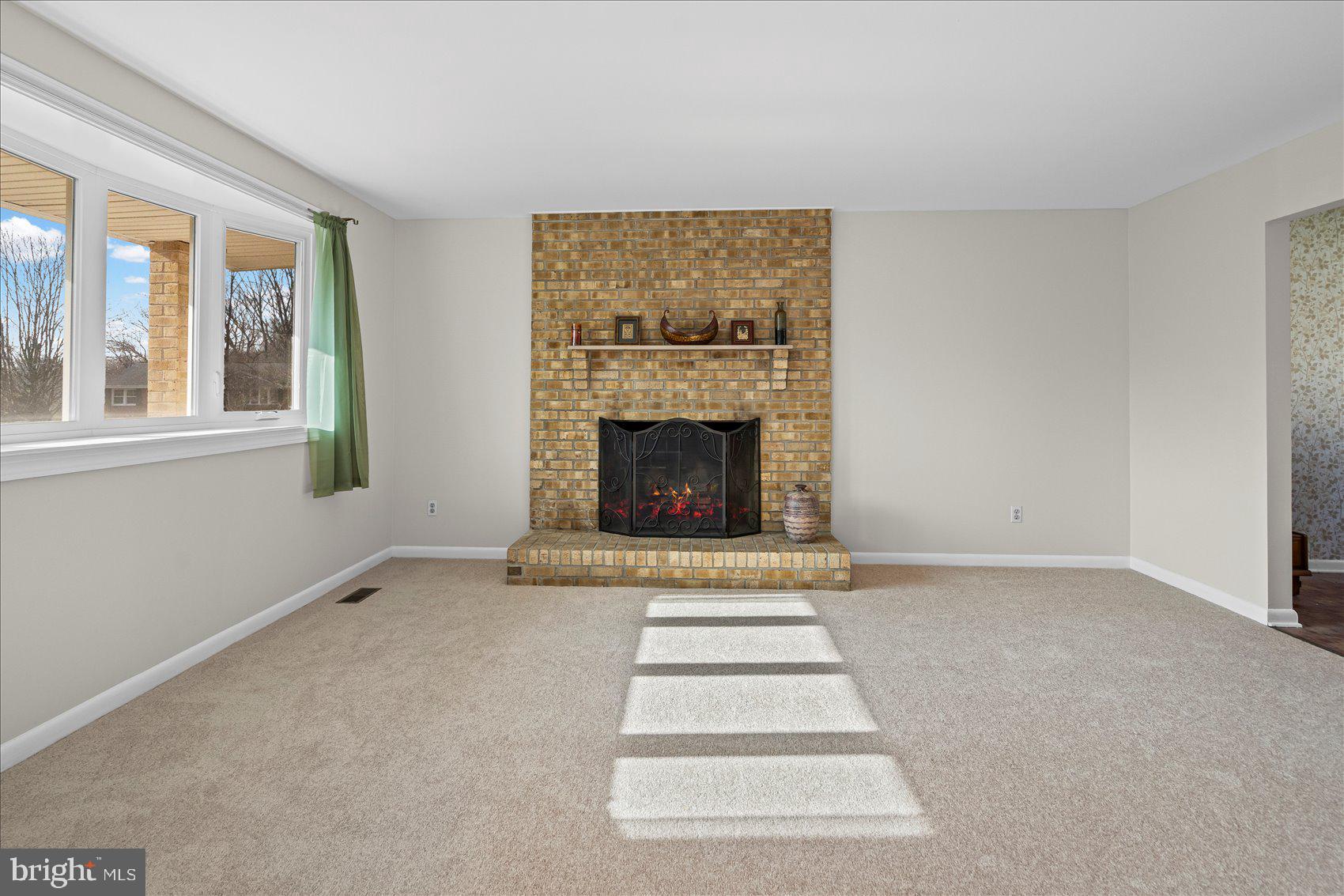4006 Silvage Road Baltimore, MD 21236 - Photo 7 of 44 a view of an empty room with a fireplace and a window