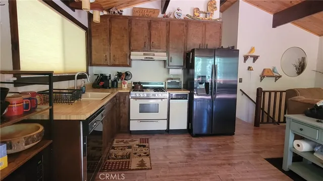 a kitchen with a sink a refrigerator and cabinets