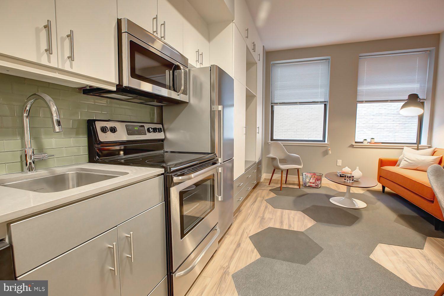 42 South 15th Street, Unit 1B0404 Philadelphia, PA 19102 - Photo 2 of 36 a kitchen with stainless steel appliances granite countertop a sink stove and cabinets