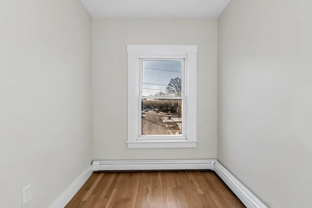 a view of a small space with wooden floor and a window