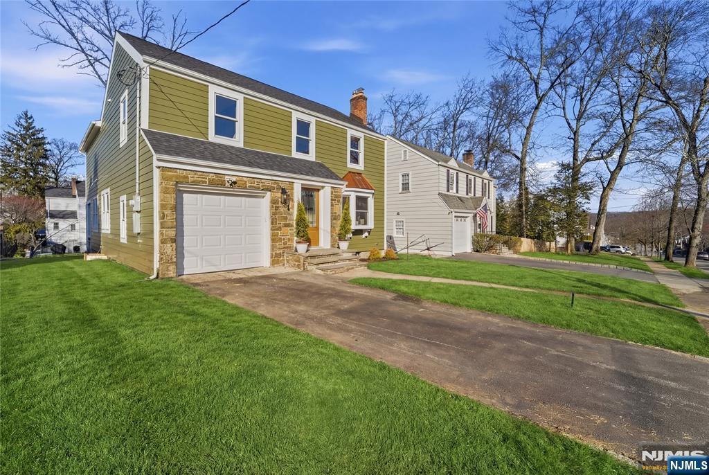 a front view of a house with a yard and trees