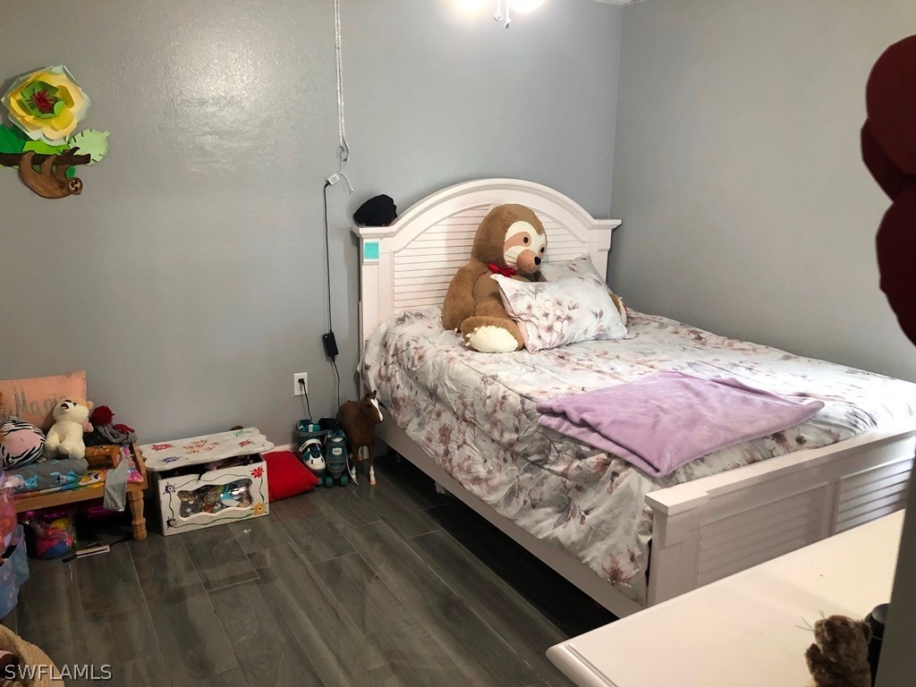 203 Roat Street Lehigh Acres, FL 33936 - Photo 11 of 15 a bedroom with a bed and a dresser in it