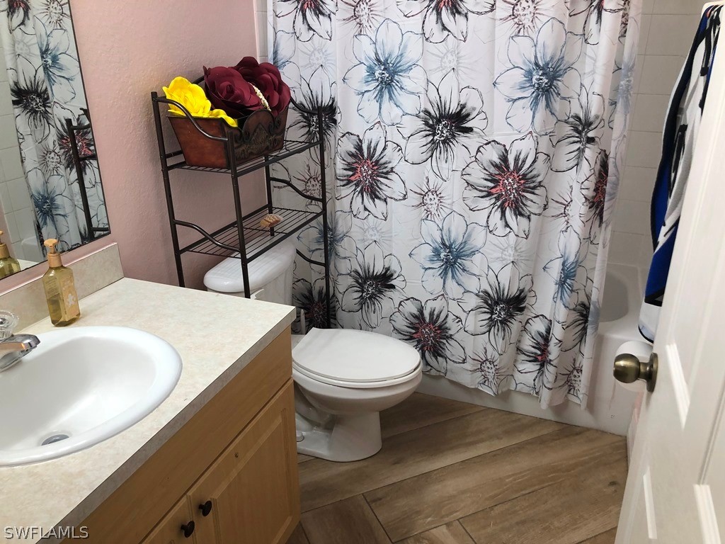 203 Roat Street Lehigh Acres, FL 33936 - Photo 12 of 15 a bathroom with a toilet sink and mirror