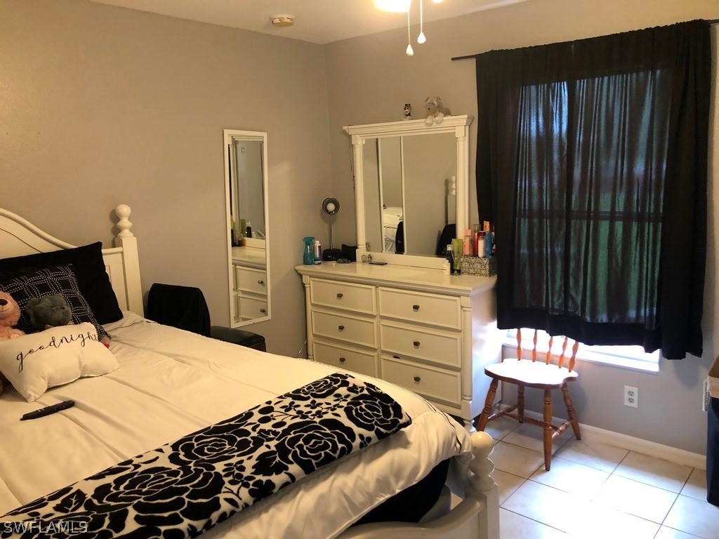 203 Roat Street Lehigh Acres, FL 33936 - Photo 13 of 15 a bedroom with a bed and a dresser