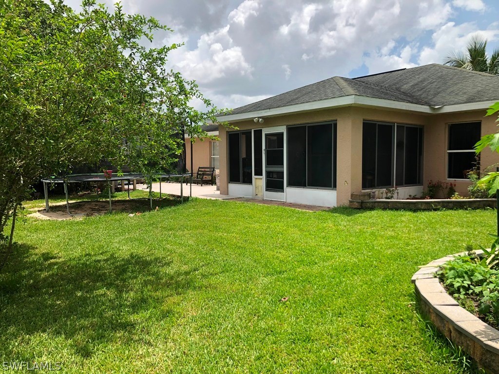203 Roat Street Lehigh Acres, FL 33936 - Photo 5 of 15 a view of a house with a yard and sitting area