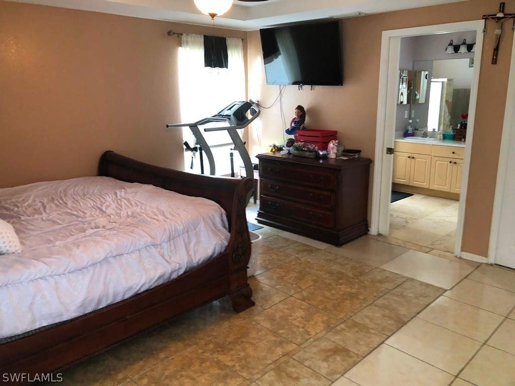 203 Roat Street Lehigh Acres, FL 33936 - Photo 8 of 15 a bedroom with a bed and a flat screen tv