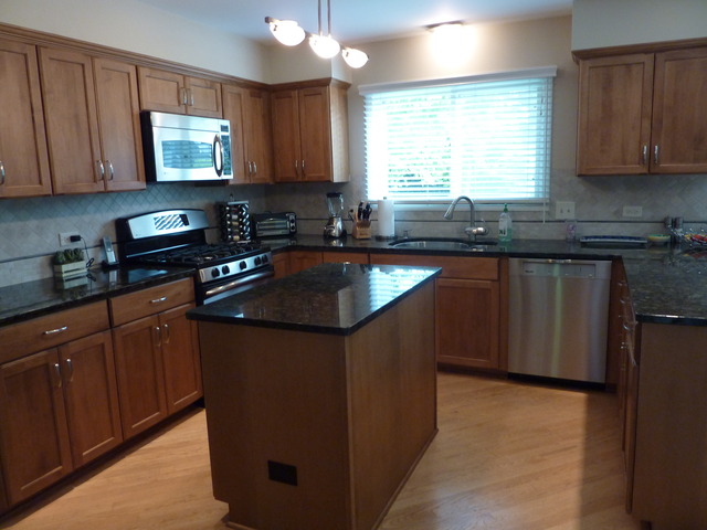 631 Raintree Road Buffalo Grove, IL 60089 - Photo 9 of 22 a kitchen with stainless steel appliances granite countertop a sink stove and microwave