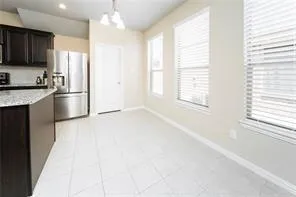 a kitchen with stainless steel appliances granite countertop a refrigerator a sink dishwasher a oven with white cabinets and wooden floor