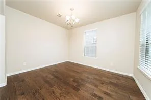 en empty room with windows and chandelier