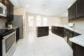 a kitchen with stainless steel appliances granite countertop a stove top oven sink and cabinets