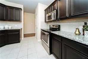 a kitchen with stainless steel appliances granite countertop a sink stove and microwave