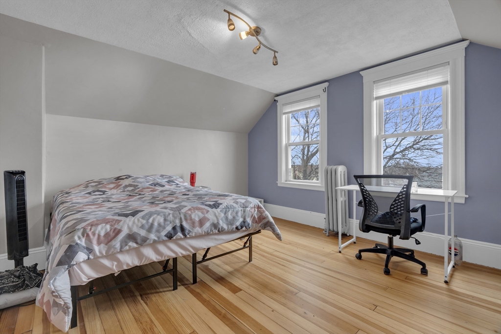 64 Commonwealth Road Watertown, MA 02472 - Photo 22 of 23 a bedroom with a bed a table and chair