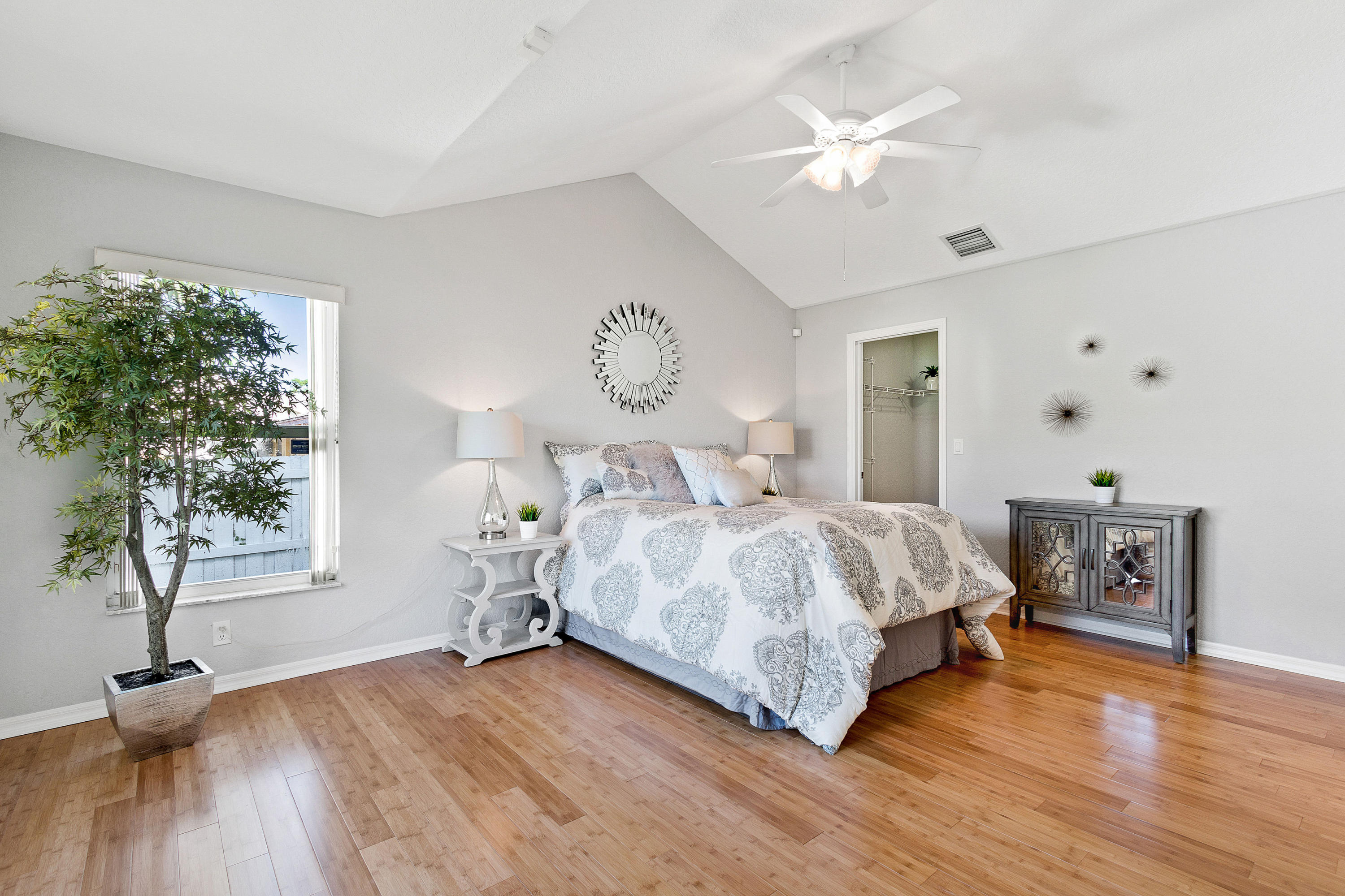 5317 Palm Ridge Boulevard Delray Beach, FL 33484 - Photo 20 of 39 a bedroom with a bed and a table with wooden floor
