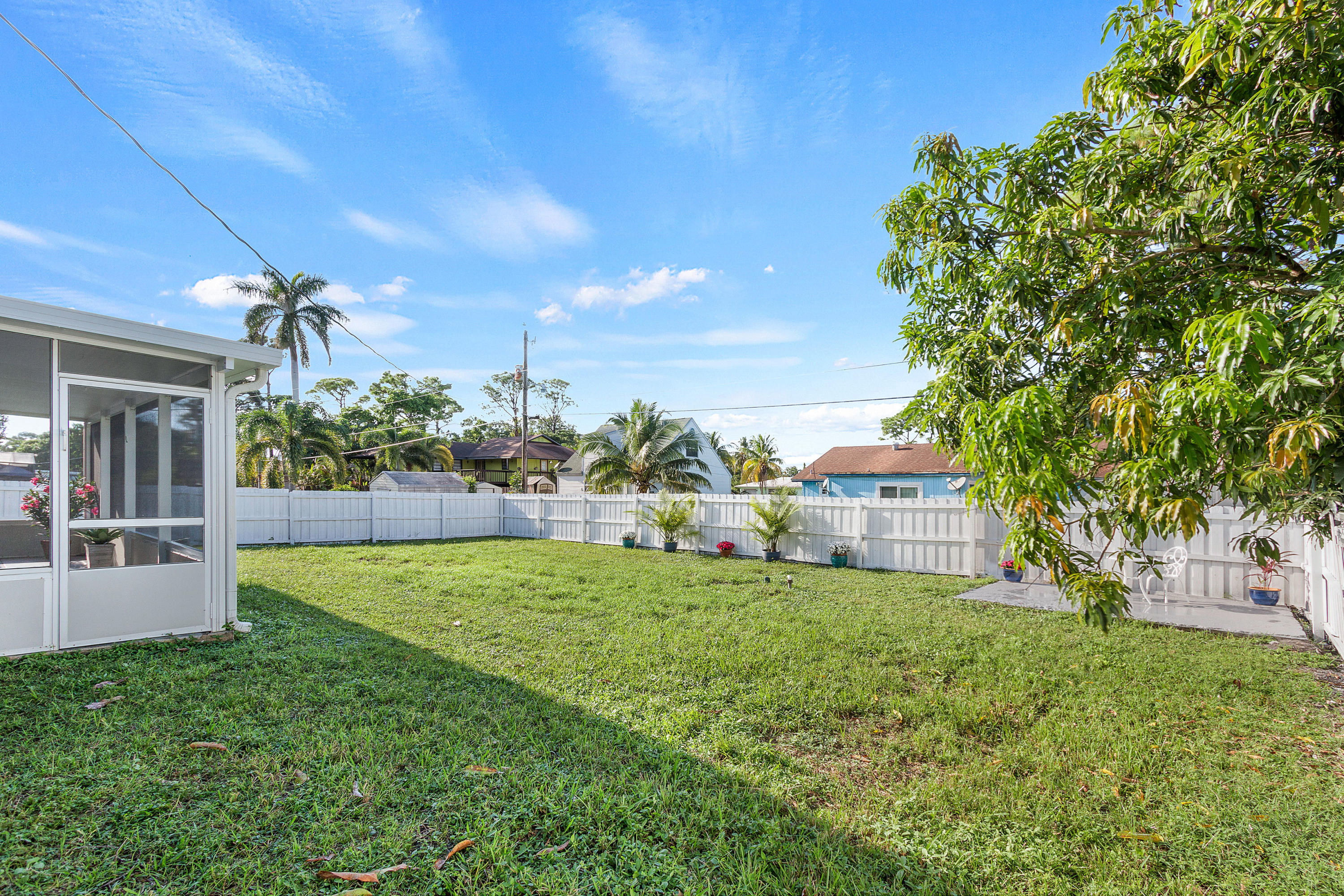 5317 Palm Ridge Boulevard Delray Beach, FL 33484 - Photo 36 of 39 a view of a house with a big yard and potted plants