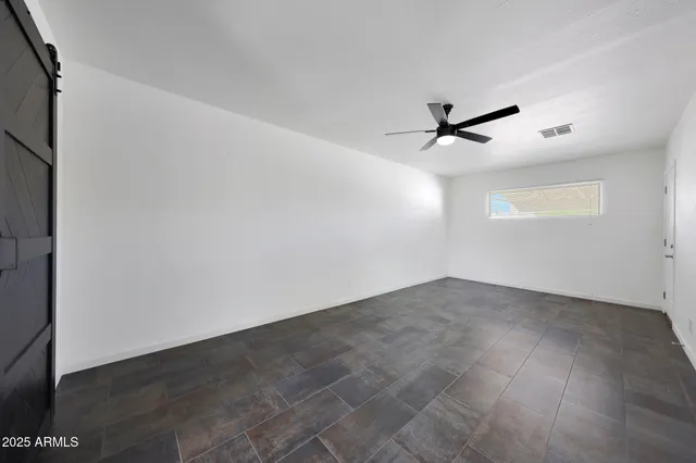 an empty room with a ceiling fan and a window