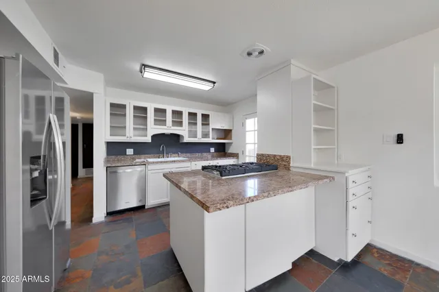 a kitchen with stainless steel appliances granite countertop a refrigerator sink and stove