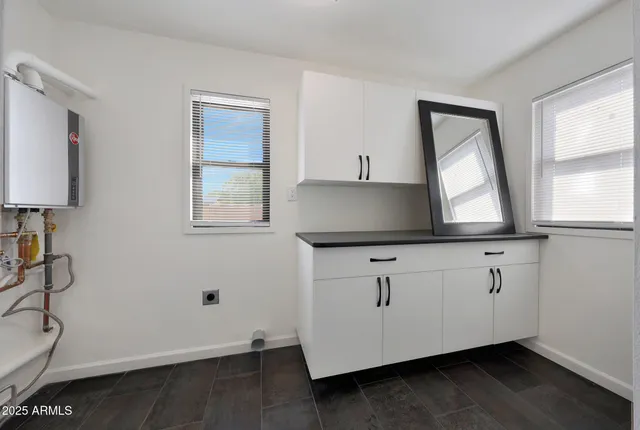 a kitchen with granite countertop white cabinets and window