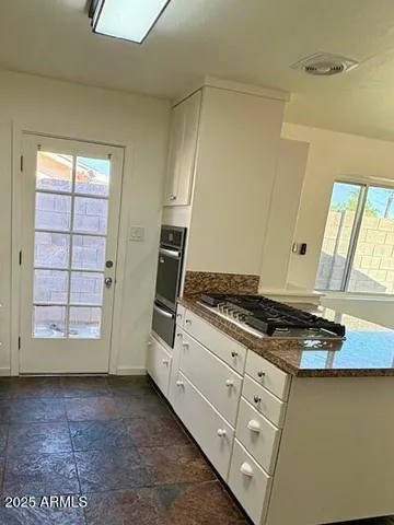 a view of kitchen with stove top oven