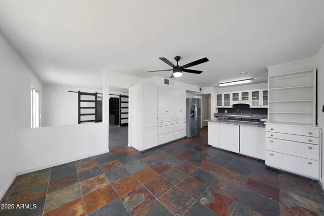 a kitchen with a refrigerator and white cabinets