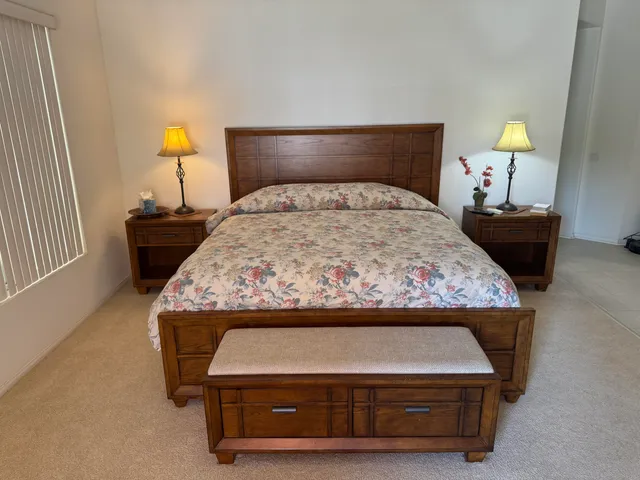 a bed sitting in a bedroom next to a lamp