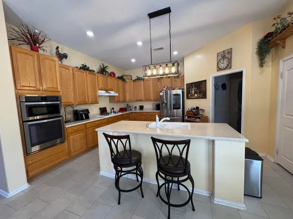 a kitchen with stainless steel appliances a table chairs and a refrigerator