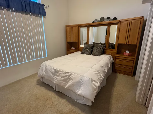 a bed sitting in a bedroom next to a window