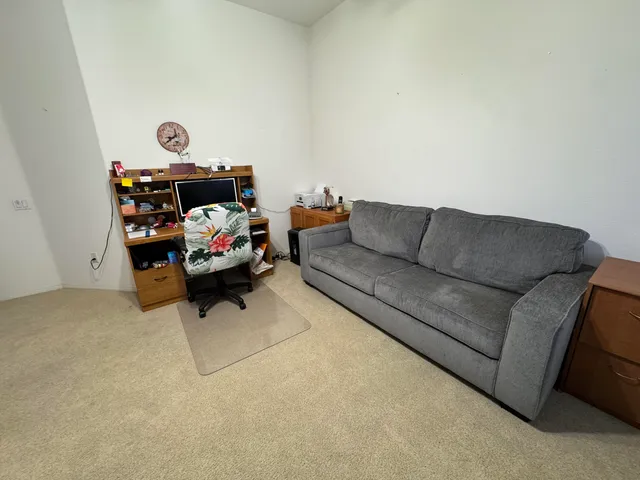 a living room with furniture and a shelf