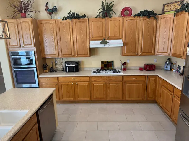 a kitchen with stainless steel appliances a sink a counter top space cabinets and a window