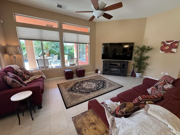 a living room with furniture a flat screen tv and a large window