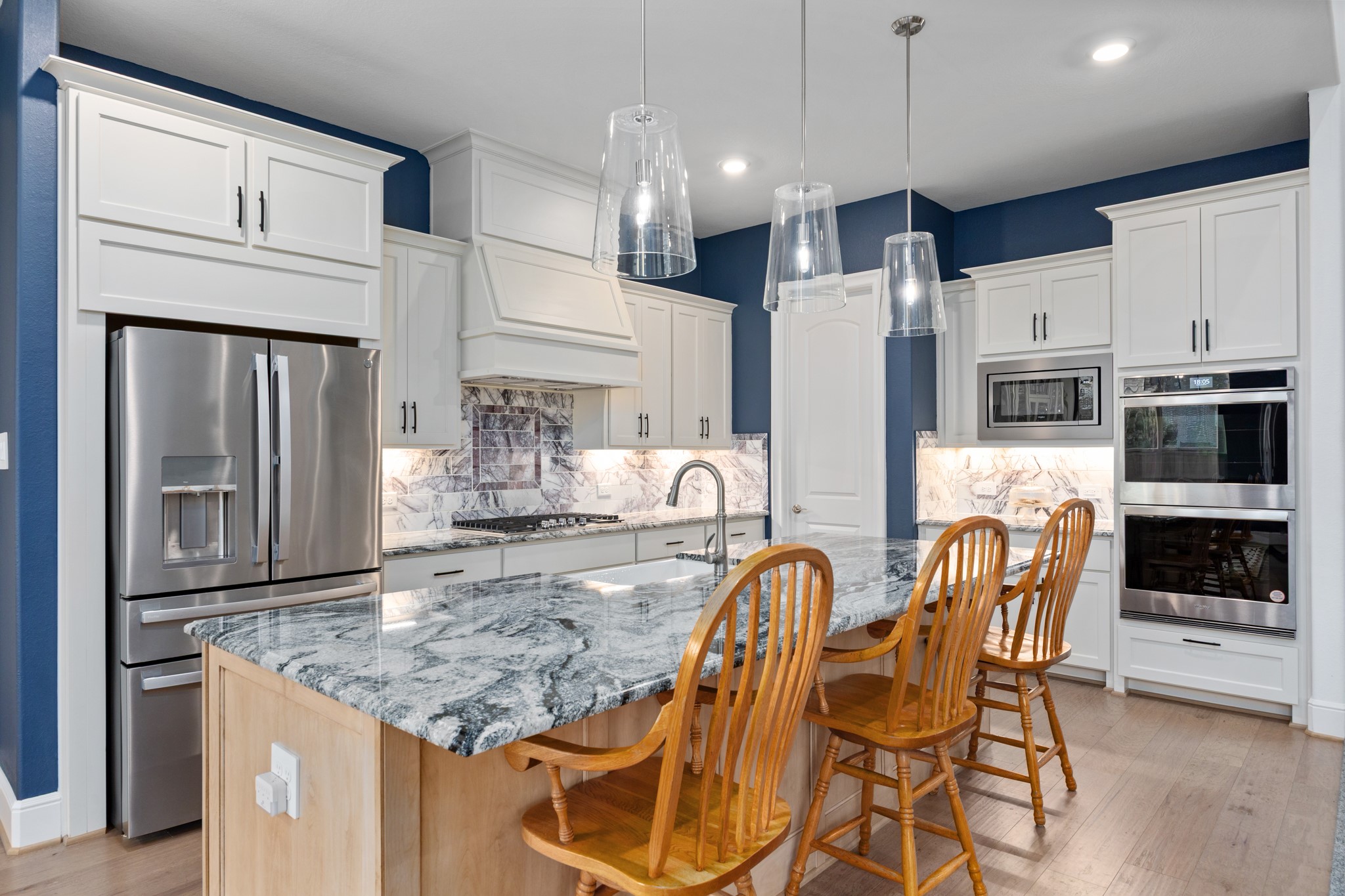 8538 Tynan Ridge Drive Magnolia, TX 77354 - Photo 30 of 50 a kitchen with stainless steel appliances granite countertop a kitchen island hardwood floor and a refrigerator