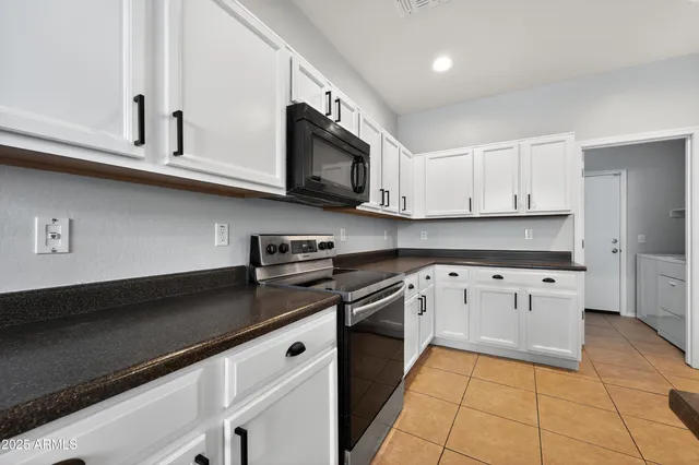 a kitchen with stainless steel appliances granite countertop a sink a stove top oven and cabinets