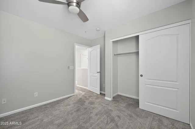 an empty room with a window and a ceiling fan