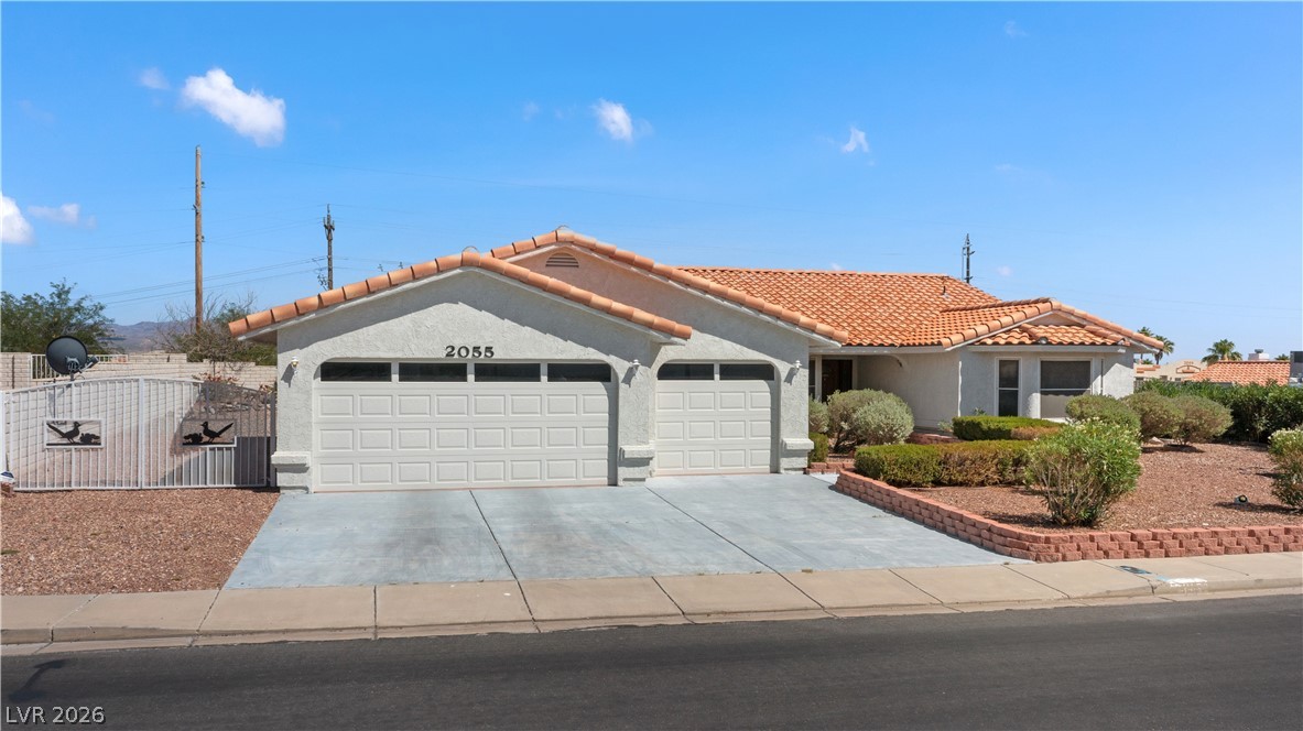 2055 Cholla Way Laughlin, NV 89029 - Photo 69 of 87 A well-maintained facade features a double garage and desert landscaping.
