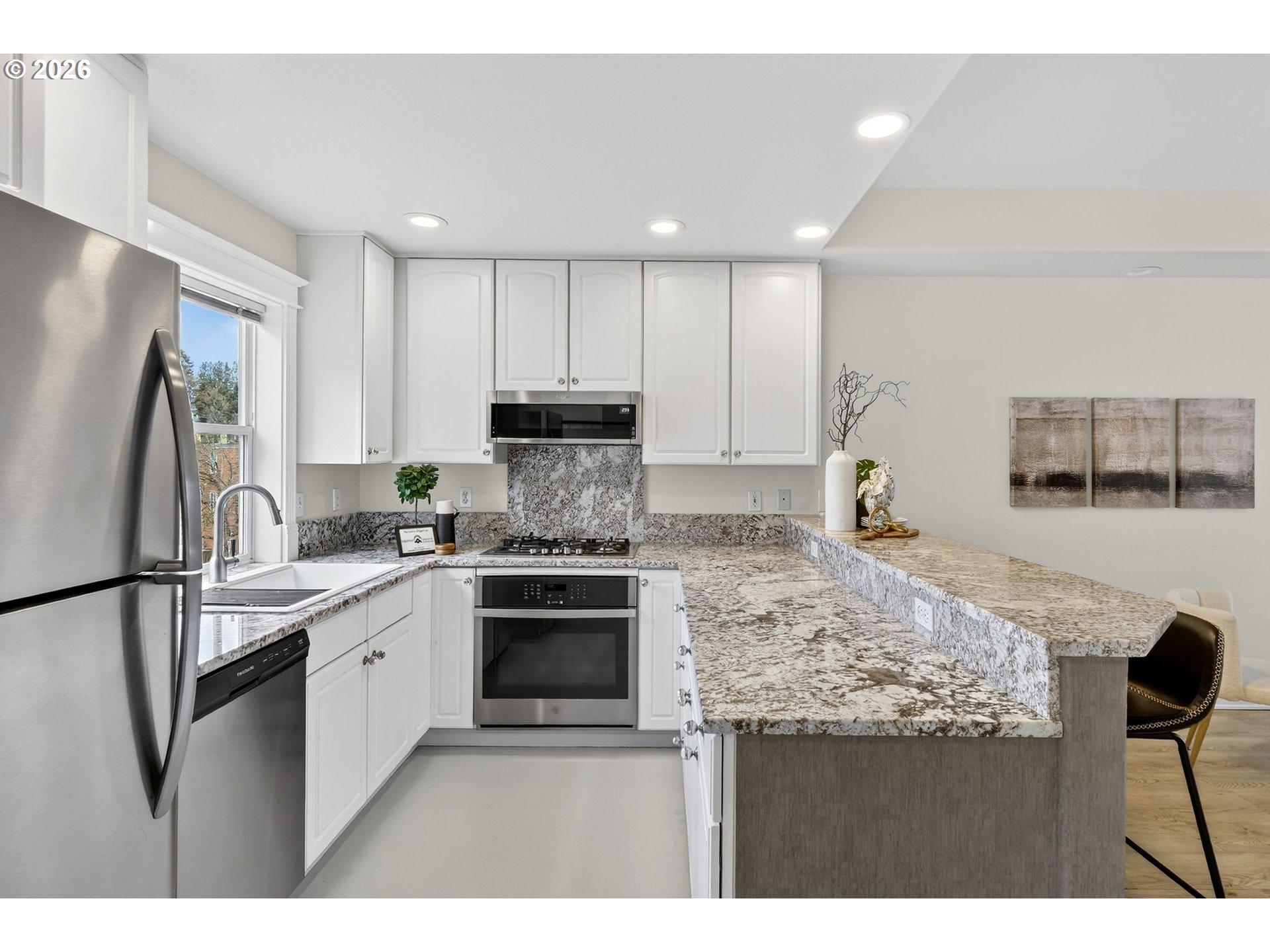 4934 Southwest 1st Avenue Portland, OR 97239 - Photo 13 of 33 a kitchen with kitchen island granite countertop a stove sink and refrigerator