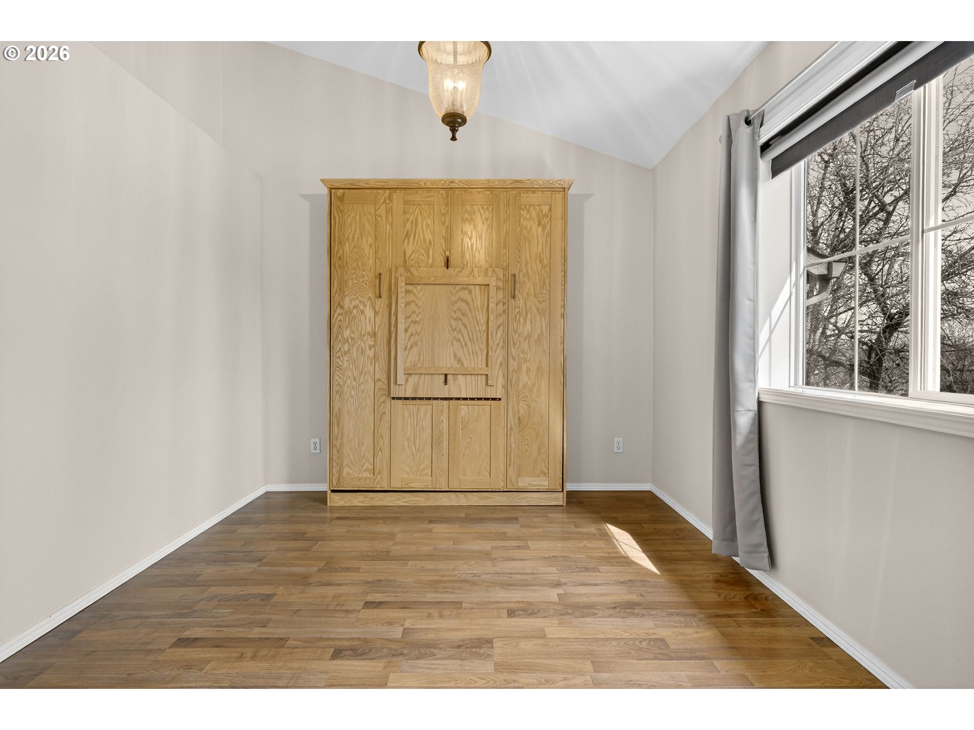 4934 Southwest 1st Avenue Portland, OR 97239 - Photo 21 of 33 a view of an empty room with wooden floor and a window