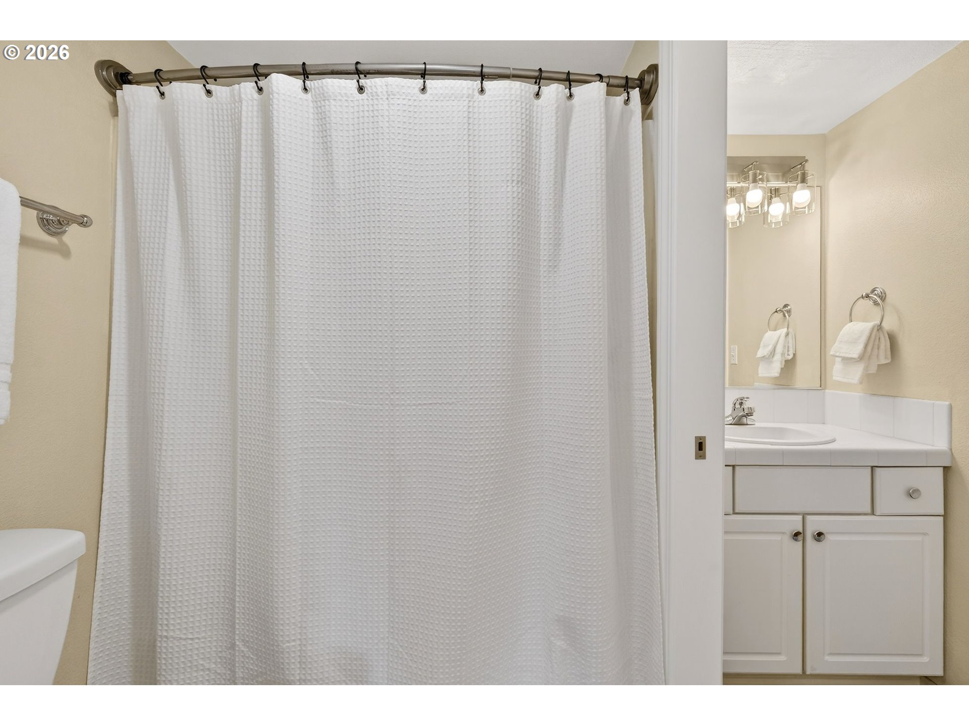 4934 Southwest 1st Avenue Portland, OR 97239 - Photo 23 of 33 a bathroom with a sink a mirror and a shower curtain