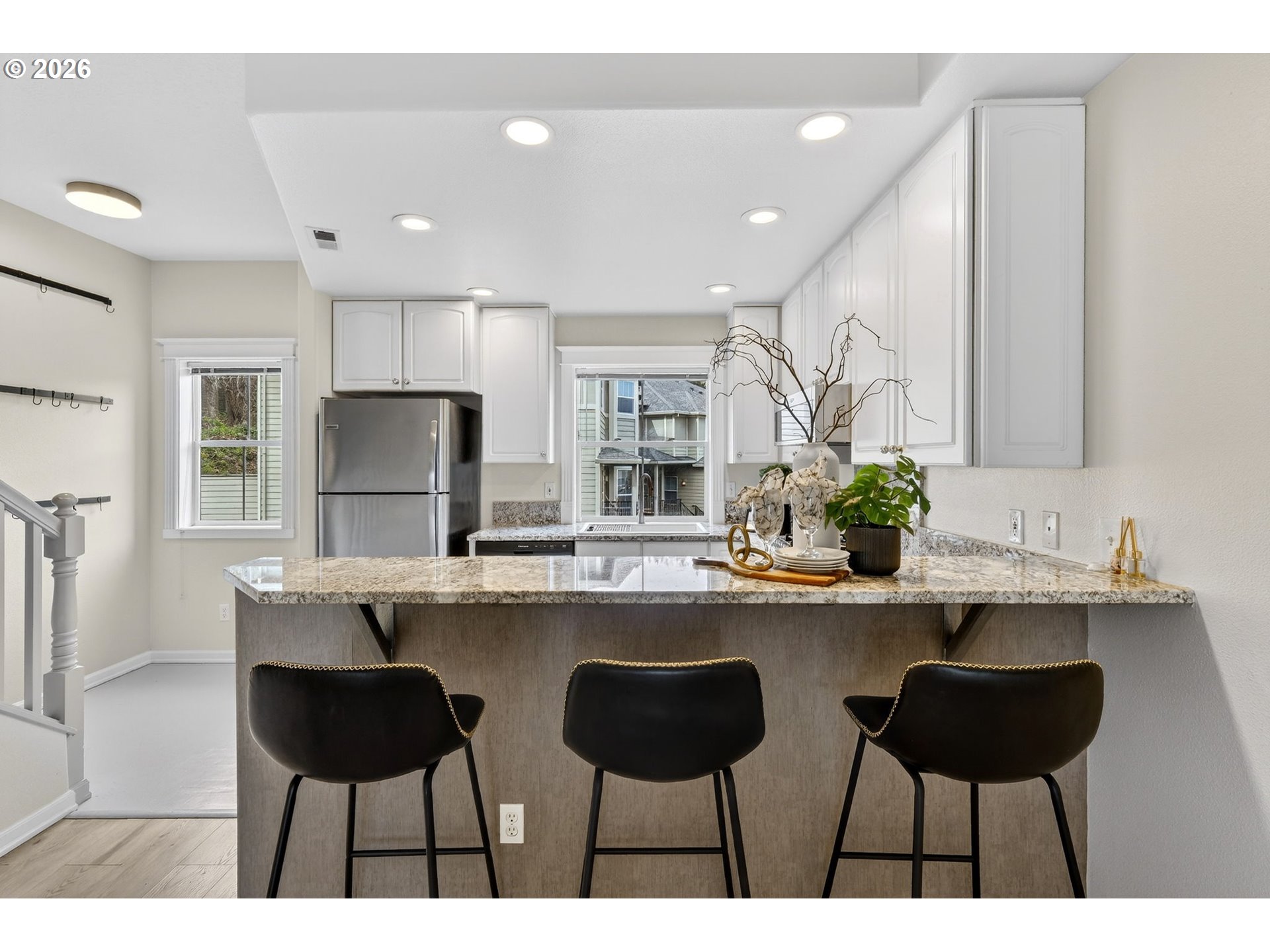 4934 Southwest 1st Avenue Portland, OR 97239 - Photo 9 of 33 a kitchen with stainless steel appliances a dining table chairs and a refrigerator