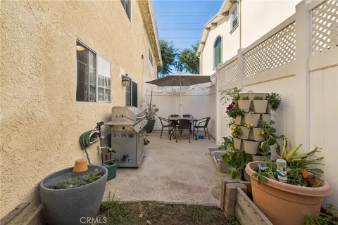 a view of a patio with table and chairs potted plants