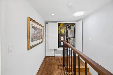 a view of a hallway with wooden floor and stairs