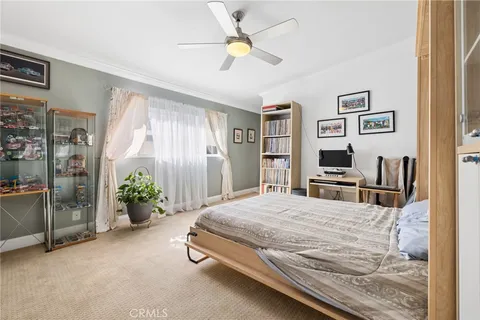 a bedroom with a bed and a flat tv screen on dresser