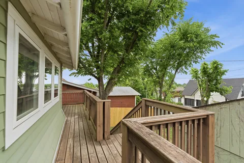 a balcony with wooden floor and outdoor seating