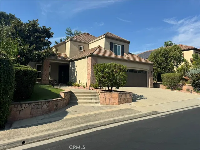 a view of a house with a yard and potted plants